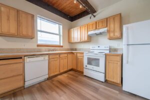 Kitchen with light wood cabinets, white appliances, and natural light. 2808 NE MLK Blvd APT 26, Portland, OR 97212. Spaces for rent by NWV Group.