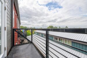 Balcony with metal railing and view of surrounding buildings. 2808 NE MLK Blvd APT 26, Portland, OR 97212. Spaces for rent by NWV Group.