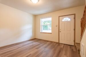 Living room with front door and window. 4616 NE Irving St #4614, Portland, OR 97213. Spaces for rent by NWV Group.