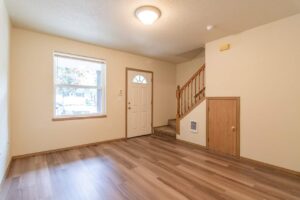 Living room with staircase and closet. 4616 NE Irving St #4614, Portland, OR 97213. Spaces for rent by NWV Group.