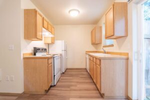 Full kitchen view with wood cabinets. 4616 NE Irving St #4614, Portland, OR 97213. Spaces for rent by NWV Group.