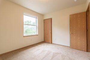 Bedroom with dual doors and carpet. 4616 NE Irving St #4614, Portland, OR 97213. Spaces for rent by NWV Group.