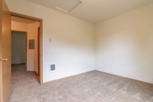 Carpeted bedroom with hallway access. 4616 NE Irving St #4614, Portland, OR 97213. Spaces for rent by NWV Group.