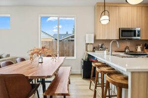 Wooden dining table with bench seating by a bright window. 6417 N Greeley Ave #4, Portland, OR 97217. Spaces for rent by NWV Group.