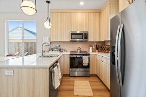 Modern kitchen with stainless steel appliances and wood cabinets. 6417 N Greeley Ave #4, Portland, OR 97217. Spaces for rent by NWV Group.