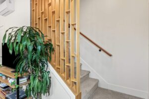 Carpeted stairs with a decorative wooden partition. 6417 N Greeley Ave #4, Portland, OR 97217. Spaces for rent by NWV Group.