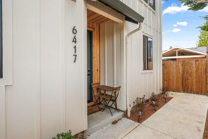 Front door area with small table and fenced backyard. 6417 N Greeley Ave #4, Portland, OR 97217. Spaces for rent by NWV Group.