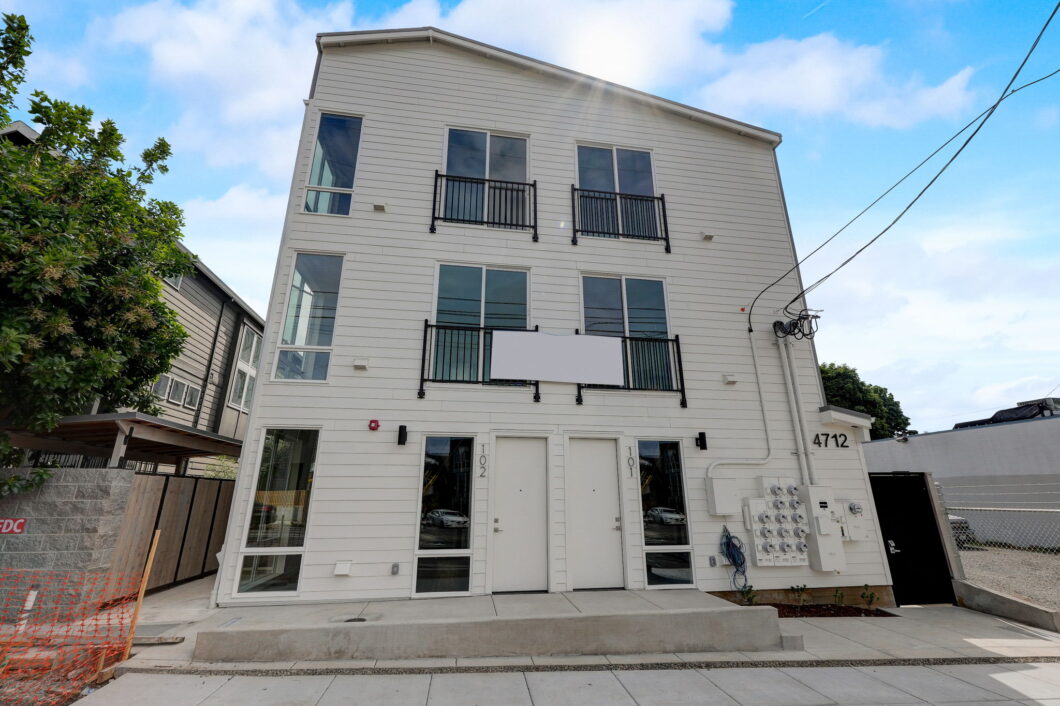 Exterior of modern three-story building with balconies and dual entry doors. Spaces for rent by NWV Group at 4712 N Williams Ave #204.