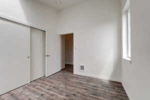 Bedroom with wood floors, sliding closet doors, and natural light. Spaces for rent by NWV Group at 4712 N Williams Ave #204.