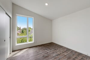 Bedroom with tall window and wood flooring, bright and spacious. Spaces for rent by NWV Group at 4712 N Williams Ave #204.