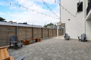 Large patio with paver stones, wooden benches, and outdoor seating. Spaces for rent by NWV Group at 4712 N Williams Ave #204.