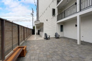 Paved courtyard area with Adirondack chairs, wooden fencing, and string lights. Spaces for rent by NWV Group at 4712 N Williams Ave #204.