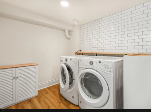 Laundry room with washer, dryer, and subway tile backsplash. Spaces for rent by NWV Group. 125 NE Shaver St #B, Portland, OR 97212.