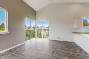 Bright living room with corner windows and balcony access. Spaces for rent by NWV Group at 4712 N Williams Ave #204.