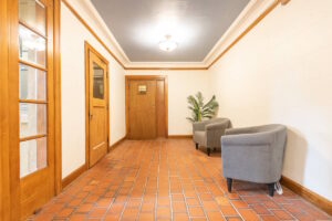 Hallway with tiled floors, gray chairs, and plants. Spaces for rent by NWV Group. 1210 SE 20th Ave APT 103, Portland, OR 97214.