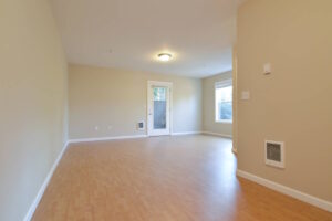 Spacious living room with wood flooring and door leading outside. Spaces for rent by NWV Group at 6928 N Greenwich Ave APT 2.