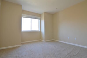 Bright bedroom with beige walls and carpet. Spaces for rent by NWV Group at 6928 N Greenwich Ave APT 2.