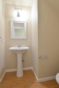 Small bathroom with pedestal sink and mirror. Spaces for rent by NWV Group at 6928 N Greenwich Ave APT 2.