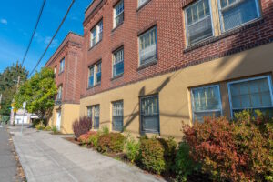 Side view of brick building with sidewalk landscaping. Spaces for rent by NWV Group. 1210 SE 20th Ave APT 103, Portland, OR 97214.