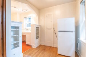 Kitchen entry with white cabinets and a refrigerator. Spaces for rent by NWV Group. 1210 SE 20th Ave APT 103, Portland, OR 97214.