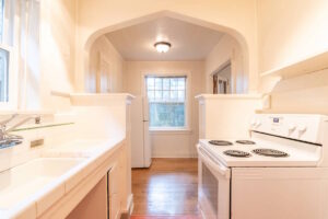 View of the kitchen with stove and white appliances. Spaces for rent by NWV Group. 1210 SE 20th Ave APT 103, Portland, OR 97214.