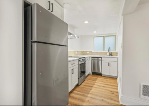 Modern kitchen with stainless steel appliances and wood flooring. Spaces for rent by NWV Group. 125 NE Shaver St #B, Portland, OR 97212.