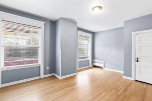 Spacious room with blue-gray walls and large windows. 2233 NW Flanders St APT 9, Portland, OR 97210. Spaces for rent by NWV Group.